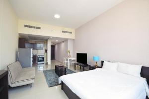 a bedroom with a large white bed and a kitchen at KeyHost - Frankfurt 1307 in Dubai