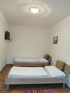 um quarto com duas camas e uma televisão na parede em Hotel Goldene Krone em Mistelbach