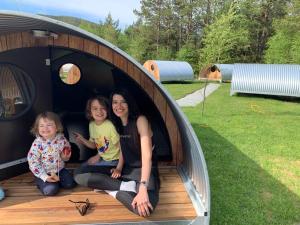a woman and two little girls sitting in a hobbit house at Hikers & Bikers camp, Part of Preikestolen BaseCamp - Preikestolen trailhead in Jørpeland