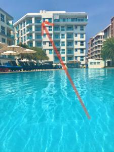a swimming pool with a red rope in the water at GrandBlue Condominium Mae Phim TOP FLOOR WITH SEA VIEW 706 in Mae Pim