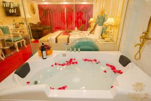 bañera blanca con flores rojas en una habitación en King's Hotel Dịch Vọng, en Hanói