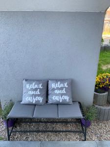 two pillows sitting on a bench against a wall at Apartamenty "Marynarska " Rusinowo in Rusinowo
