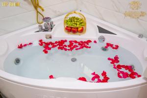 Una bañera llena de flores y una cesta de fruta. en King's Hotel Dịch Vọng, en Hanói