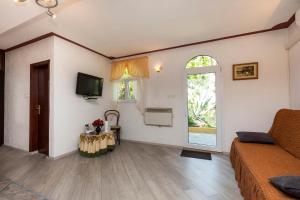 a room with a bed and a tv and a window at Apartman Maya in Mali Lošinj