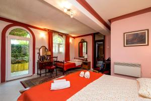 a bedroom with a bed with a red blanket and a room at Apartman Maya in Mali Lošinj