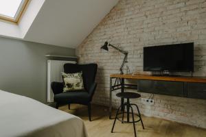 a bedroom with a bed and a desk with a television at Villa Antiqua in Racibórz