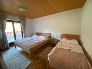 sypialnia z 2 łóżkami i oknem w obiekcie Apartments-Rooms Kocijancic w Bledzie