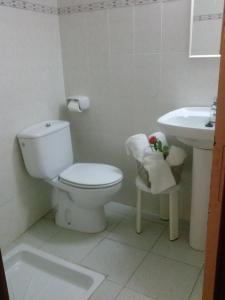 a white bathroom with a toilet and a sink at Hotel Miami in Tossa de Mar