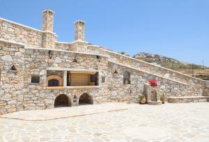 a large stone building with a stone staircase at Οasis Apartments in Amorgos