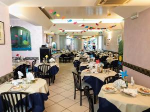 une salle à manger avec des tables à nappes bleues dans l'établissement Albergo Villa Denny, à Rimini