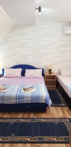 a bedroom with two beds and a nightstand with a bed sidx sidx at Smjestaj „Cubrilo" in Herceg-Novi