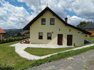 a house with a thatched roof and a driveway at Domki pod Beskidem in Jaworzynka