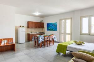 una cucina e una sala da pranzo con tavolo e frigorifero di Residence Catona a Otranto