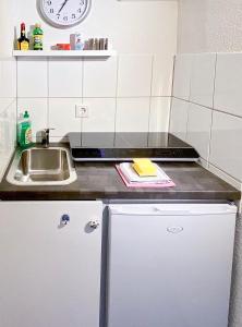 a small kitchen with a sink and a counter at Modernes Zimmer mit Küchenzeile und Bad in Groß Denkte