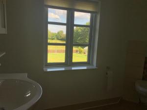 een badkamer met een wastafel en een raam bij Ferienwohnung bei Kappeln an der Schlei in Kappeln