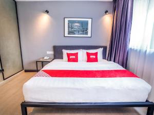 a bedroom with a large bed with two red pillows at OYO 89576 Mokka Hotel in Kuala Lumpur