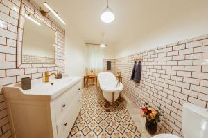 a bathroom with a sink and a toilet and a mirror at Apartmány Rodný dom Deža Hoffmanna in Banská Štiavnica