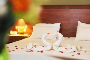 twee zwanen gemaakt om eruit te zien als harten zittend op een bed bij Esmeralda Hotel in Kremasti