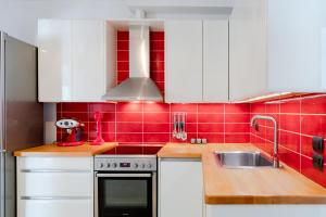 a kitchen with white cabinets and red tiles at Siora Agiolina Two-Bedroom Private Pool Villa in Argostoli