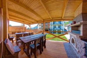 a large wooden deck with a table and a fireplace at Dolyna Gir in Bukovel