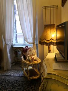 a room with a lamp on a table and a window at Felikshouse in Rome