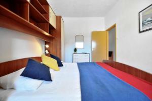 Un dormitorio con una cama grande con almohadas azules y amarillas. en Villa Senjkovic - Apartments with Balcony and Sea View, en Bol