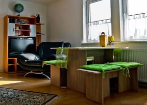 a living room with a bar with a green seat at Appartement Georg in Celle