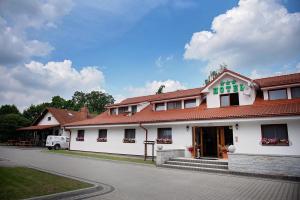 een wit gebouw met een rood dak op een straat bij Hotel Ranczo Smyczyna in Smyczyna