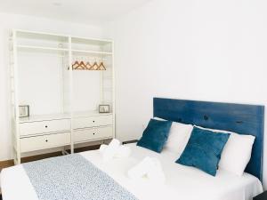 a bedroom with a blue and white bed and a mirror at Aiguaneu El Celler in Blanes