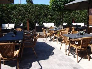 a group of tables and chairs in a patio at Hotel Mieke Pap in Poppel