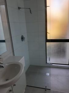 a white bathroom with a sink and a shower at City Apartment in Christchurch
