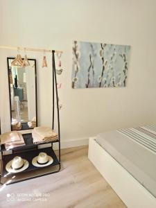 Joli appartement niçois en bord de mer في نيس: طاولة تزيين مع قبعات ومرآة في غرفة النوم