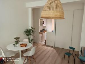 a dining room with a white table and chairs at Joli appartement niçois en bord de mer in Nice