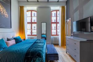 une chambre avec un lit et une télévision à écran plat dans l'établissement Loft Apartments Leipzig Loft Aqua, à Leipzig