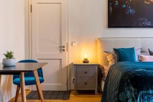 une chambre avec un lit, une table et une chaise dans l'établissement Loft Apartments Leipzig Loft Aqua, à Leipzig