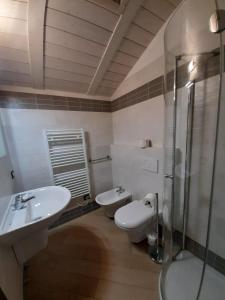 La salle de bains est pourvue de 2 lavabos et d'une douche en verre. dans l'établissement Appartamento DELUXE 1 con vasca idromassaggio vista Lago di Garda, riscaldata, privata e utilizzabile tutto l'anno, à Brenzone