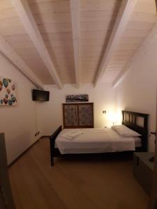ein Schlafzimmer mit einem Bett und einem TV in einem Zimmer in der Unterkunft Appartamento DELUXE 1 con vasca idromassaggio vista Lago di Garda, riscaldata, privata e utilizzabile tutto l'anno in Brenzone sul Garda