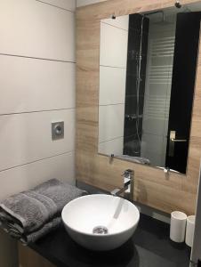 een badkamer met een witte wastafel en een spiegel bij Studio rénové - Val Claret centre - Exposition sud in Tignes