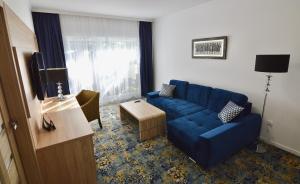 a living room with a blue couch and a window at Ameba in Mielno