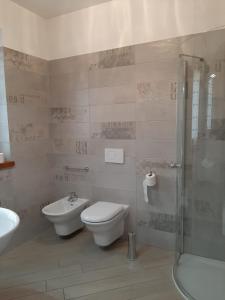 een badkamer met een toilet, een wastafel en een douche bij Appartamento DELUXE 2 con vasca idromassaggio vista Lago di Garda, riscaldata, privata e utilizzabile tutto l'anno in Brenzone sul Garda