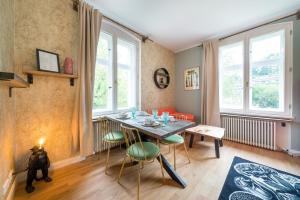 een eetkamer met een tafel, stoelen en ramen bij Design Apartments - "Villa Arnim" in Potsdam