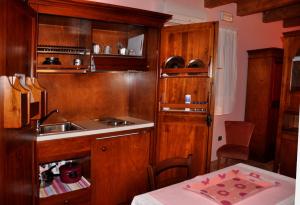 a kitchen with wooden cabinets and a sink and a table at Agriturismo Alla Casella in Ferrara