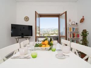 a white table with a bowl of fruit and a television at Apartment Top Floor by Interhome in Sorrento