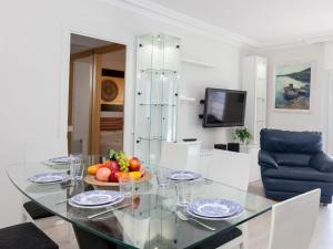 Apartment Fenals Beach by Interhome في يوريت دي مار: طاولة زجاجية مع وعاء من الفواكه عليها