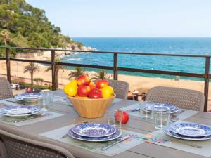 Apartment Fenals Beach by Interhome في يوريت دي مار: طاولة مع صحن من الفاكهة وإطلالة على الشاطئ