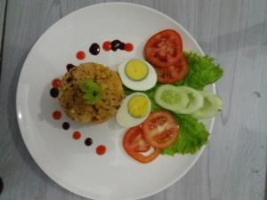 a plate of food with eggs and vegetables on it at Bale Baleku Homestay in Praya