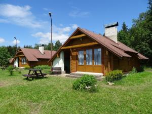 a log cabin with a picnic table in front of it at Chatky Apollo na Vysočině in Nové Město na Moravě