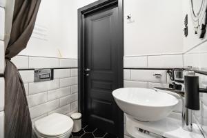 uma casa de banho com um lavatório branco e um WC. em Welcome Apartment Nevsky em São Petersburgo