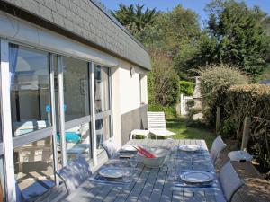 a blue table with plates and glasses on a patio at Holiday Home TY Greg by Interhome in Crozon