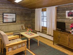 a living room with a couch and a table and a tv at Holiday Home Katajarinne by Interhome in Ruka